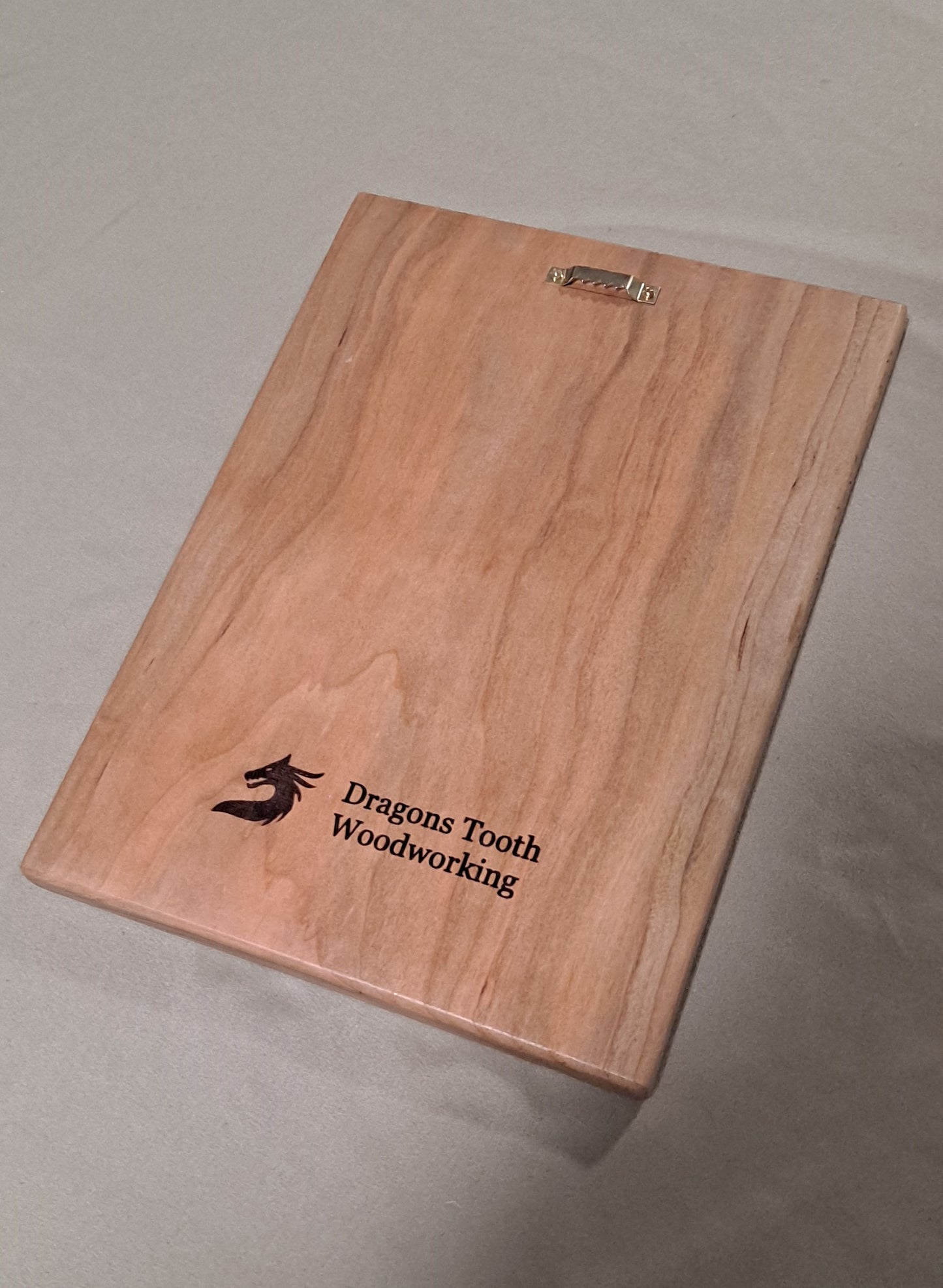 The back of a solid wood plaque showing the clean, smooth wood finish and a pre-installed, heavy-duty sawtooth hanger for wall mounting.