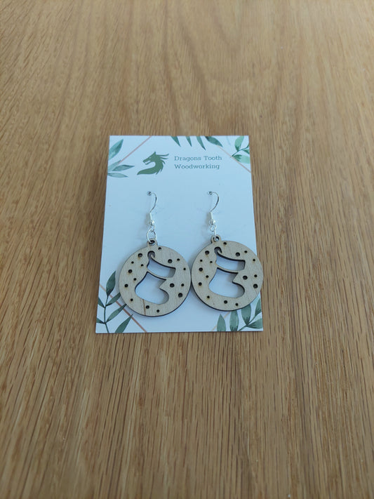 A front view of the Christmas stocking earrings crafted from light, bright blonde solid Maple wood, displayed on a clean earring card.