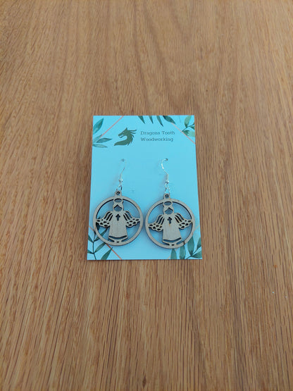 A pair of light blonde colored maple wood angel earrings displayed with silver hooks on a card with the brand name 'Dragon's Tooth Woodworking'.