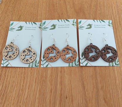 Pairs of reindeer earrings made from natural hardwoods, with silver hooks displayed on a card with 'Dragon's Tooth Woodworking' written at the top.