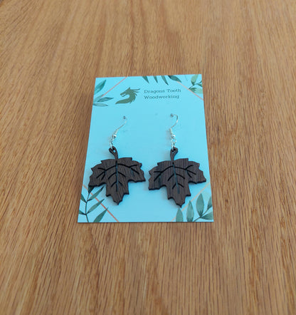 Handcrafted maple leaf earrings made from natural wood — available in maple, cherry, oak, or walnut — featuring hypoallergenic sterling silver-plated hooks and a delicate leaf silhouette, perfect for autumn-inspired outfits and nature lovers.