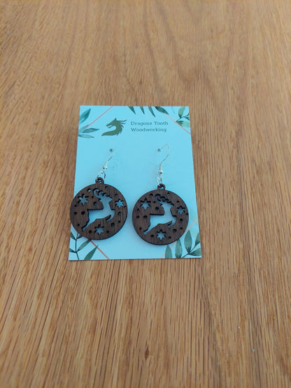 A pair of reindeer earrings made from natural black walnut wood, displayed on a card with 'Dragon's Tooth Woodworking' written at the top.