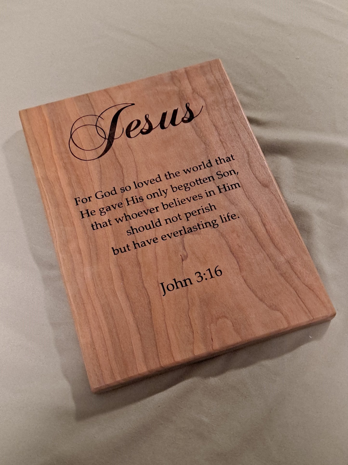 Close-up angled view showing the precision CNC engraving details on a solid wood John 3:16 scripture plaque.