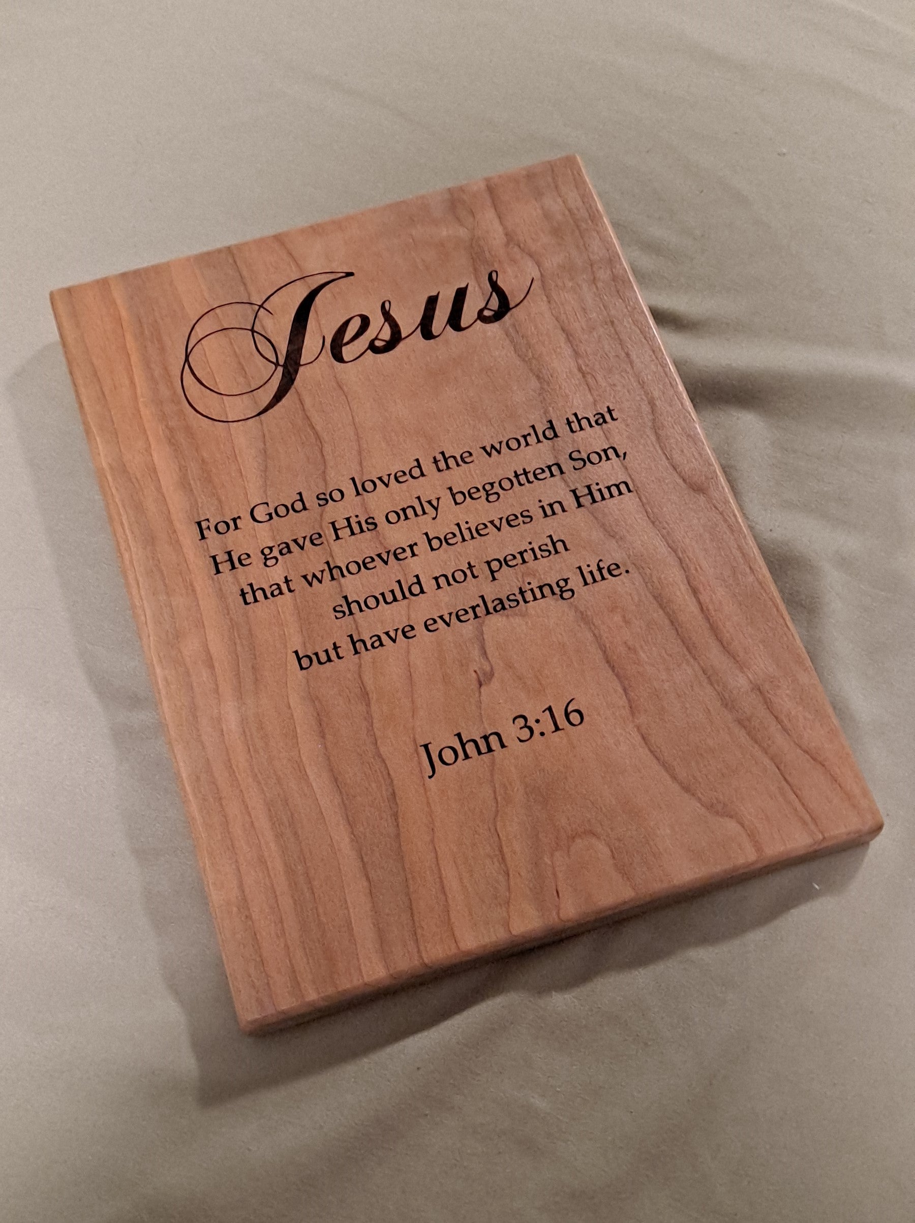 Close-up angled view showing the precision CNC engraving details on a solid wood John 3:16 scripture plaque.