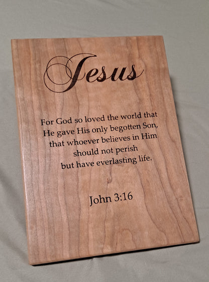 Front-facing view of a cherry wood plaque deeply engraved with the scripture text of John 3:16.