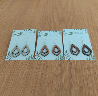An alternate view displaying the budding flower bulb earrings in three available wood types: light Maple, warm Cherry, and deep Walnut.