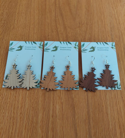 An alternate view displaying the Christmas tree earrings in three available wood types: light Maple, warm Cherry, and deep Walnut