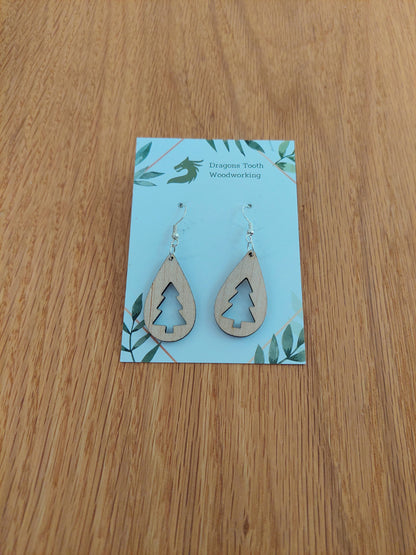 A front view of the Christmas tree teardrop earrings crafted from light, bright blonde solid Maple wood, displayed on an earring card.