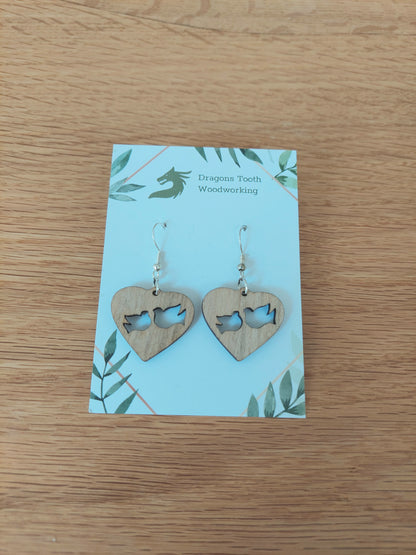 A front view of the minimalist dove earrings crafted from light, bright blonde solid Maple wood, displayed on an earring card.