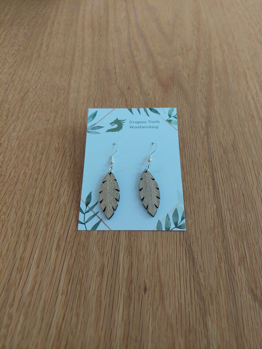 A front view of the minimalist simple leaf earrings crafted from light, bright blonde solid Maple wood, displayed on an earring card.
