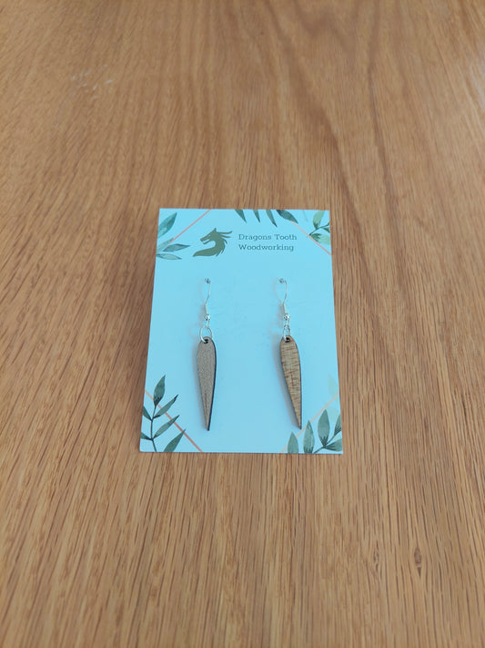 Front view of a pair of maple wood minimalist pointed geometric dangle earrings displayed on a rustic earring card.