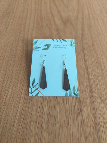 Front view of a pair of walnut wood minimalist tie silhouette geometric dangle earrings displayed on a rustic earring card.
