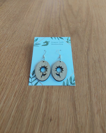 A front view of the aster flower earrings crafted from light, bright blonde solid Maple wood, displayed on an earring card