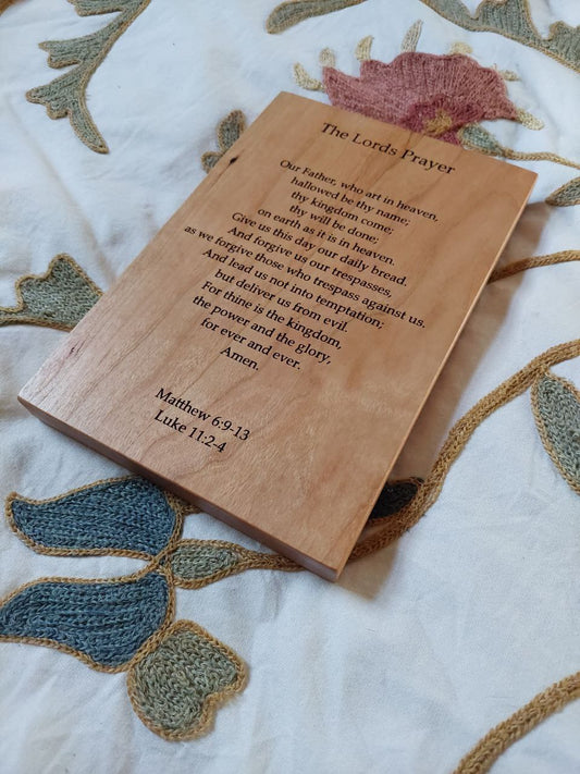 Close-up angled view showing the precision CNC engraving details on a solid wood Our Father prayer plaque.