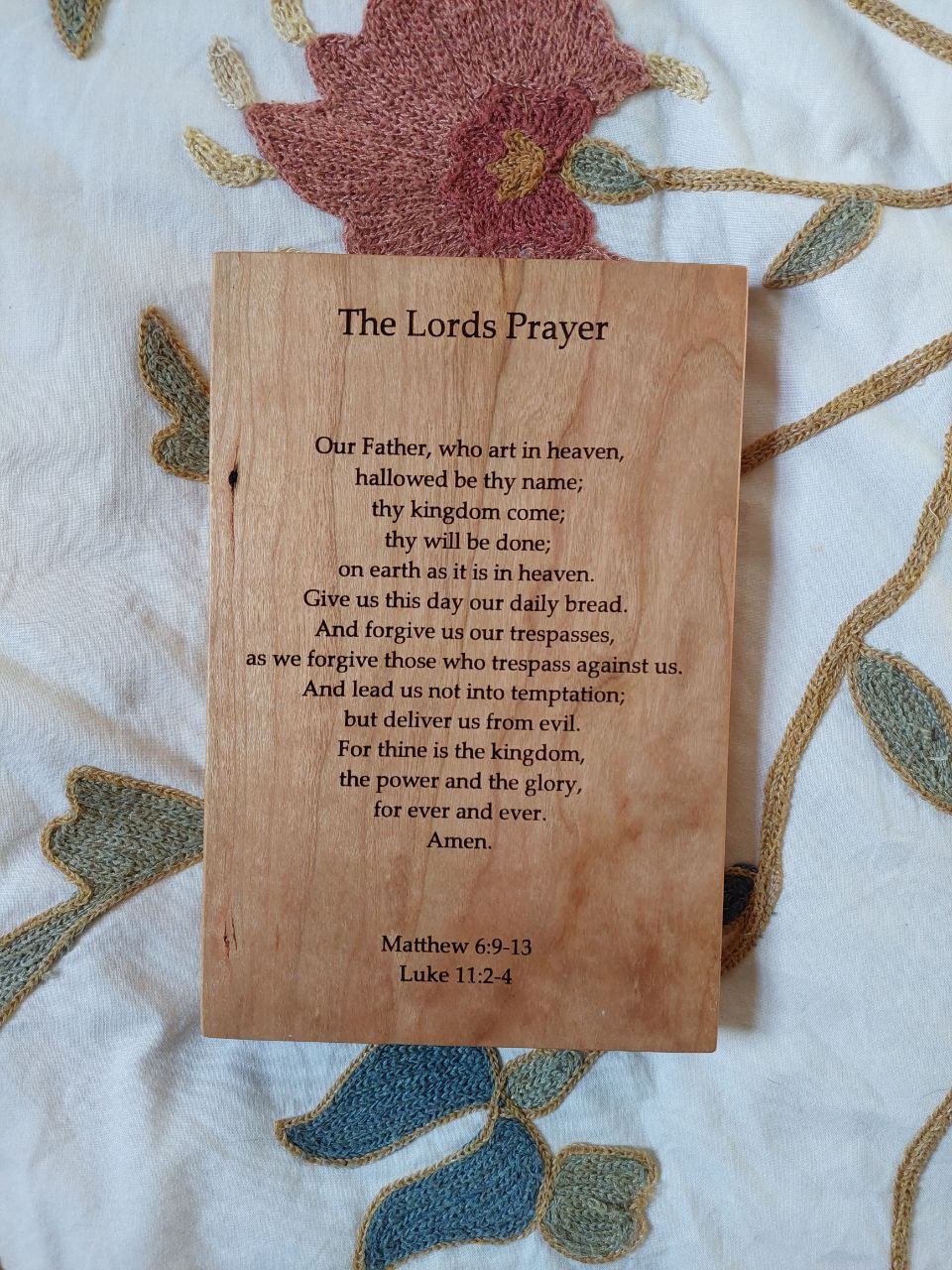 Front-facing view of a cherry wood plaque deeply engraved with the full text of The Lord's Prayer.