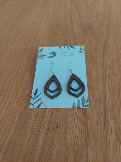 A front view of the budding flower bulb earrings crafted from rich, deep chocolate-brown solid Walnut wood, displayed on an earring card.