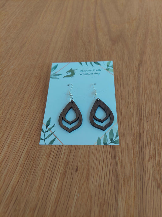 A front view of the budding flower bulb earrings crafted from rich, deep chocolate-brown solid Walnut wood, displayed on an earring card.