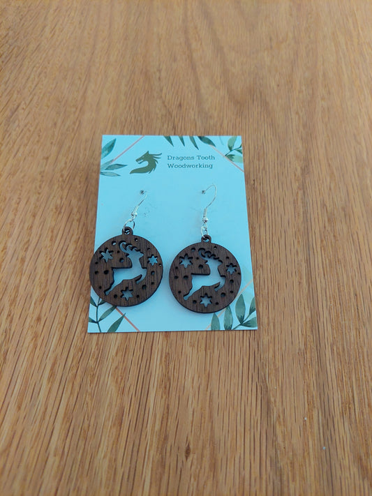 A front view of the Christmas reindeer earrings crafted from rich, deep chocolate-brown solid Walnut wood, displayed on an earring card.