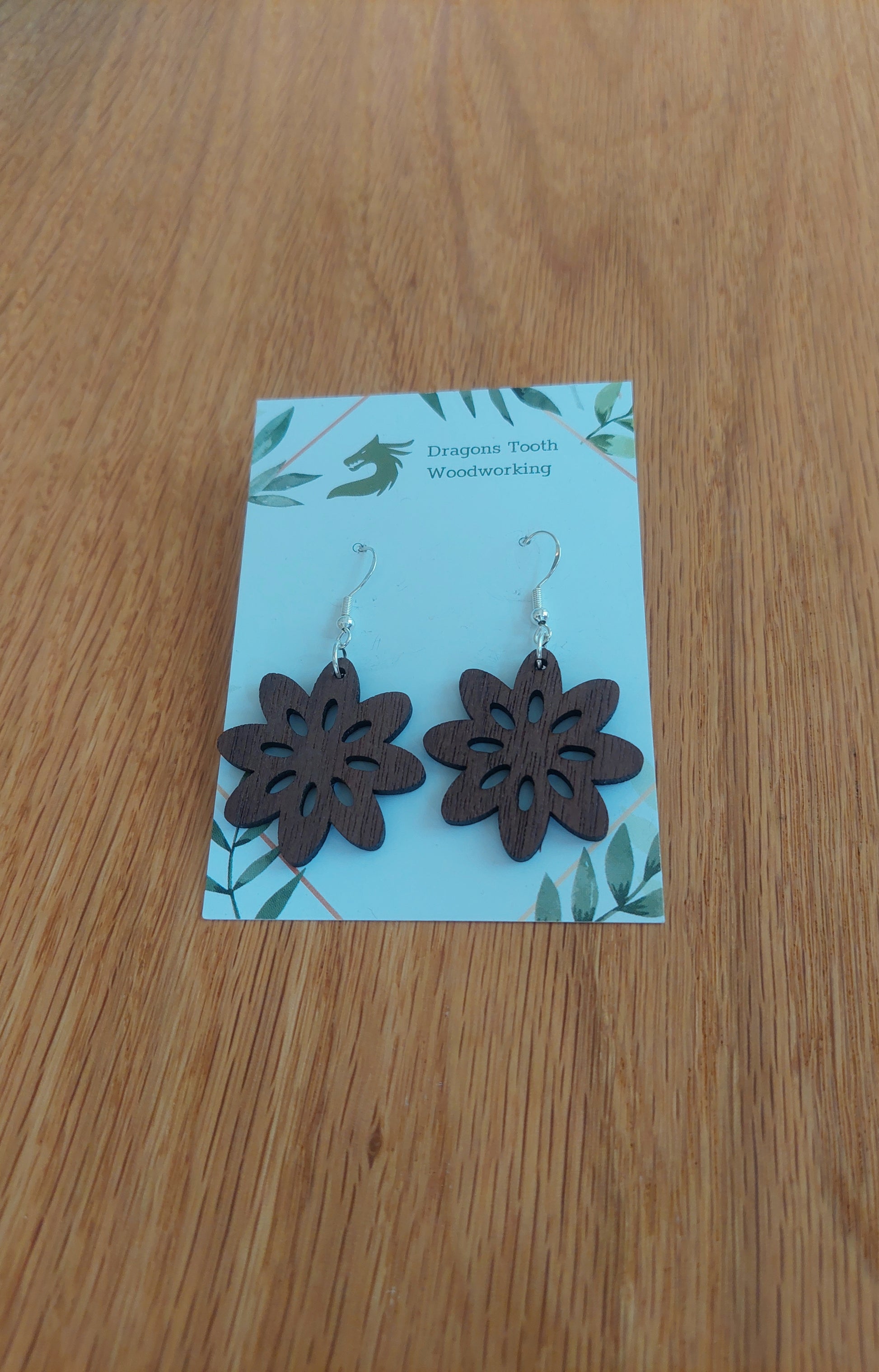 Deep chocolate brown walnut wood daisy earrings, a unique handcrafted bohemian botanical accessory.