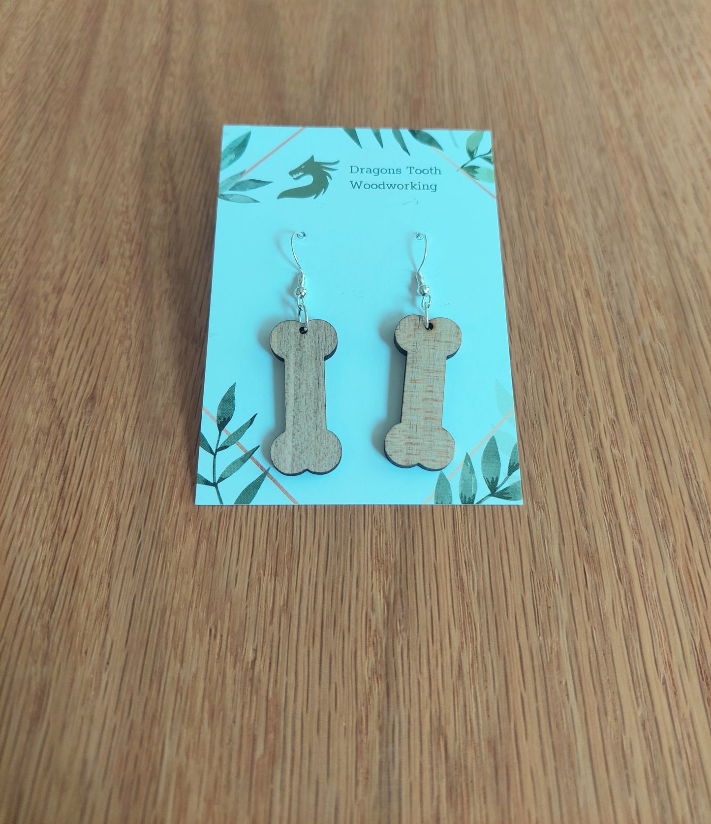 Light blonde natural maple wood dog bone earrings, a clean and minimalist pet-themed accessory handcrafted in Virginia.