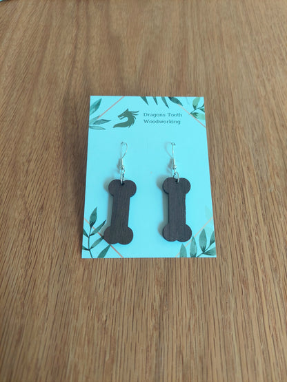 Deep chocolate brown walnut wood dog bone dangle earrings, unique handcrafted hardwood jewelry for dog lovers.