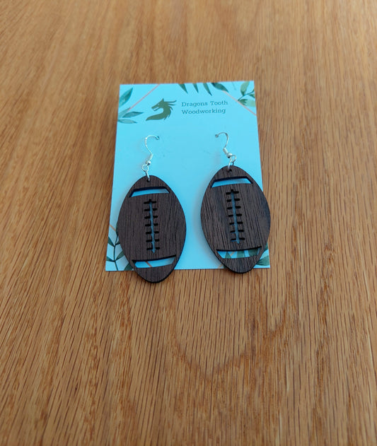 Deep chocolate brown walnut wood football earrings featuring a laser-cut texture and laces, mimicking a real leather football.