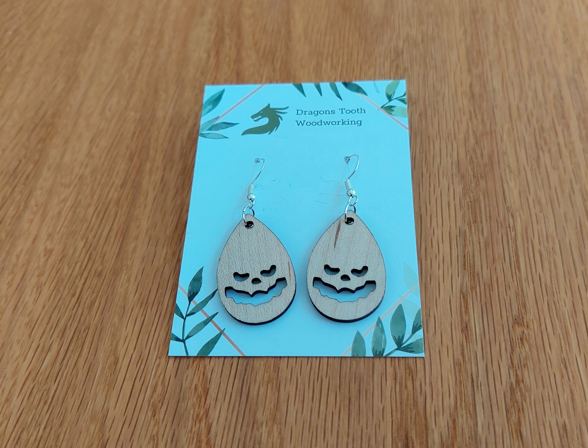 Light blonde natural maple wood jack-o-lantern earrings, a clean and minimalist pumpkin silhouette accessory handcrafted in Virginia.