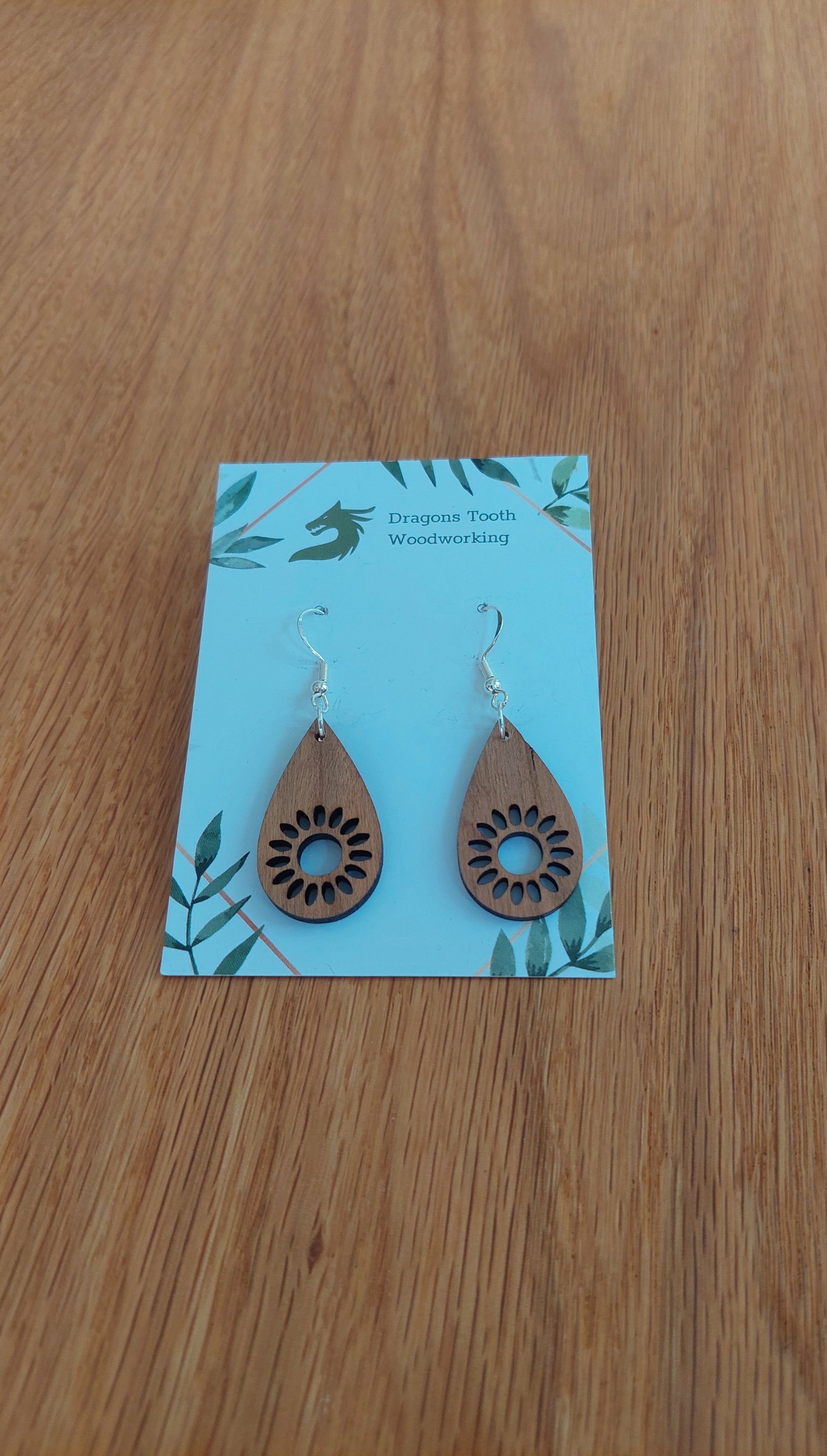 Handcrafted cherry wood sunflower dangle earrings showcasing a warm caramel-toned natural wood grain and hypoallergenic hooks.