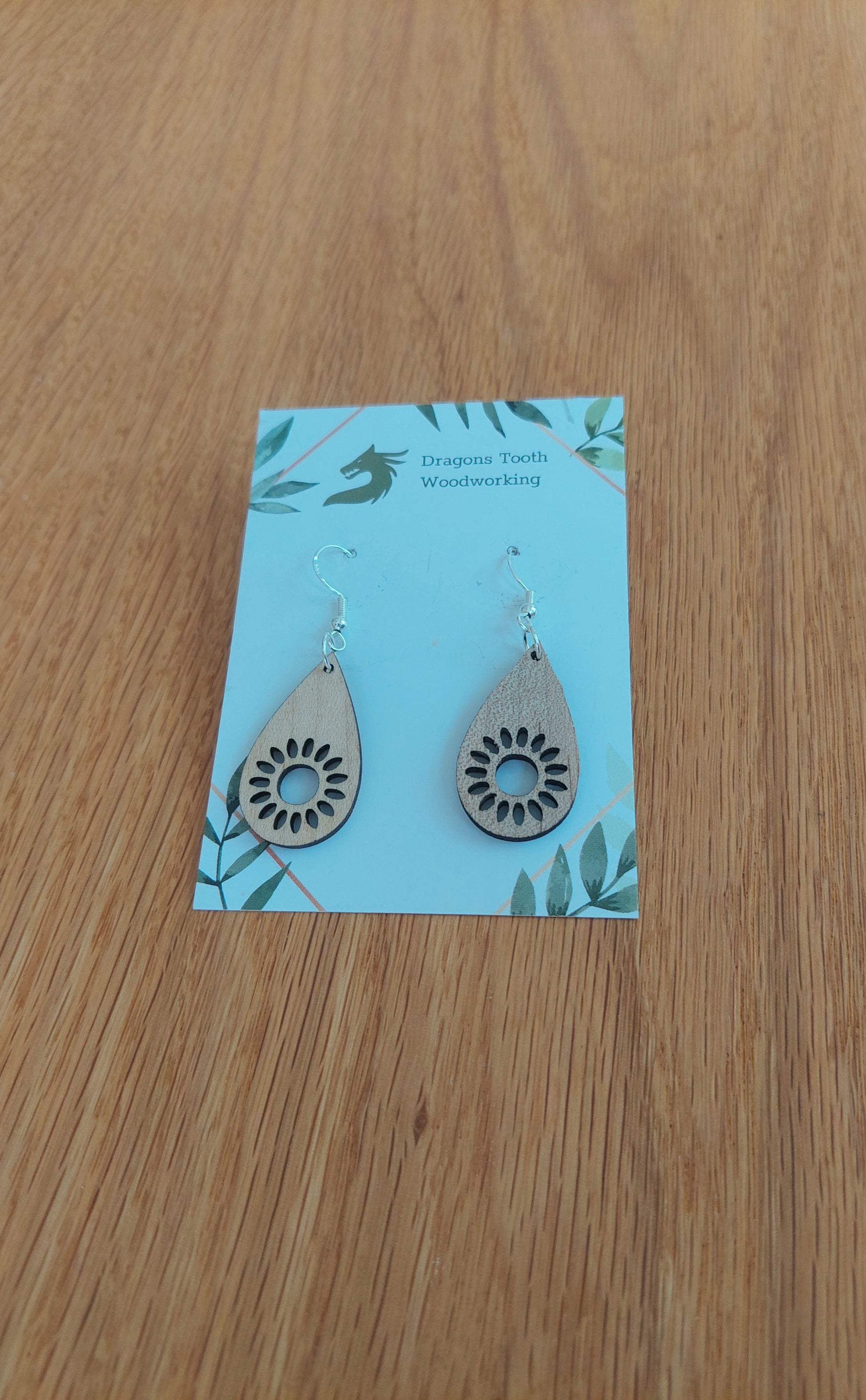 Bright blonde natural maple wood sunflower earrings featuring an intricate geometric laser-cut floral design.