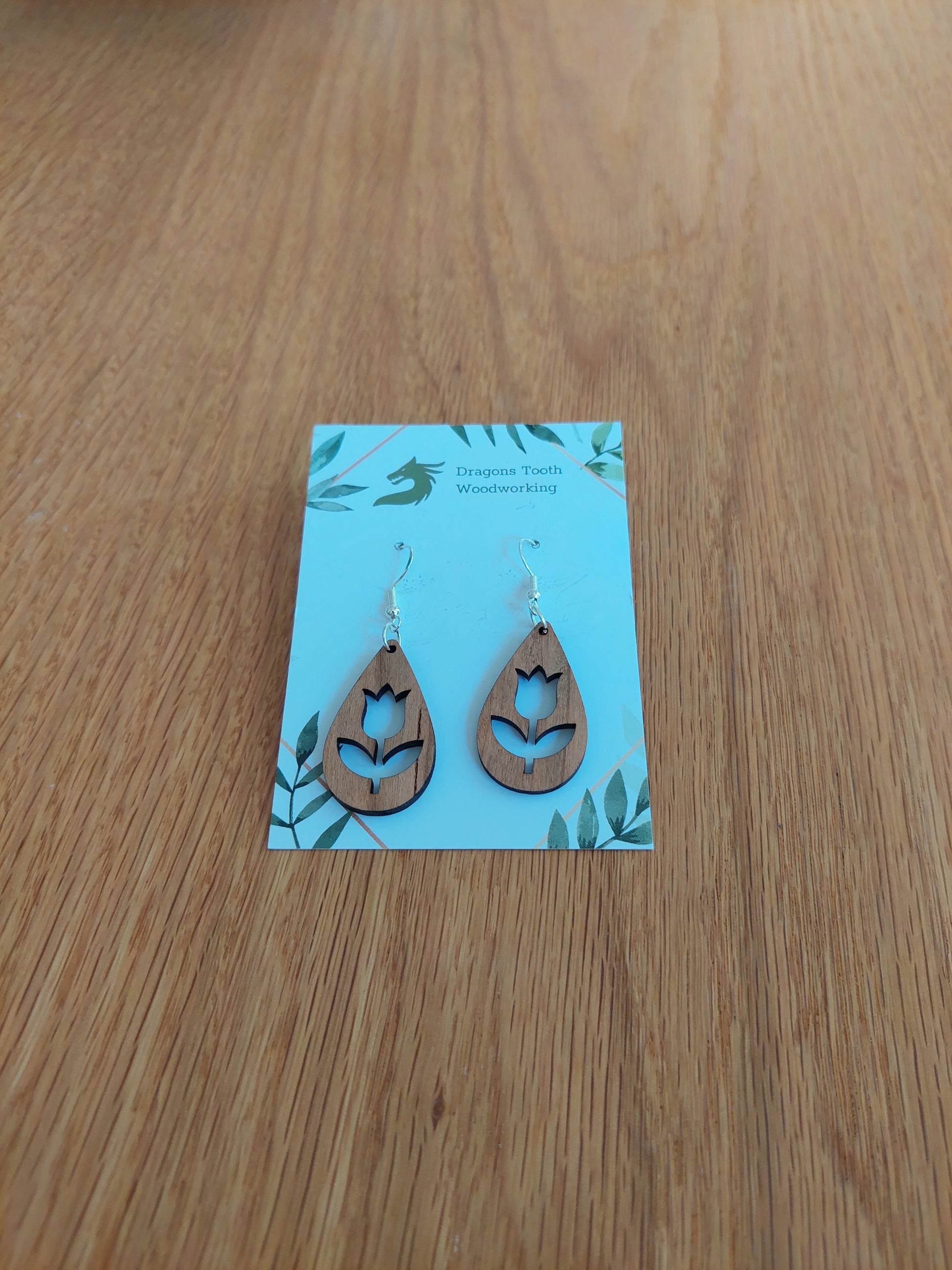 Handcrafted cherry wood tulip flower earrings showcasing a warm caramel-toned natural wood grain with hypoallergenic hooks.