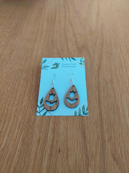 Handcrafted cherry wood tulip flower earrings showcasing a warm caramel-toned natural wood grain with hypoallergenic hooks.