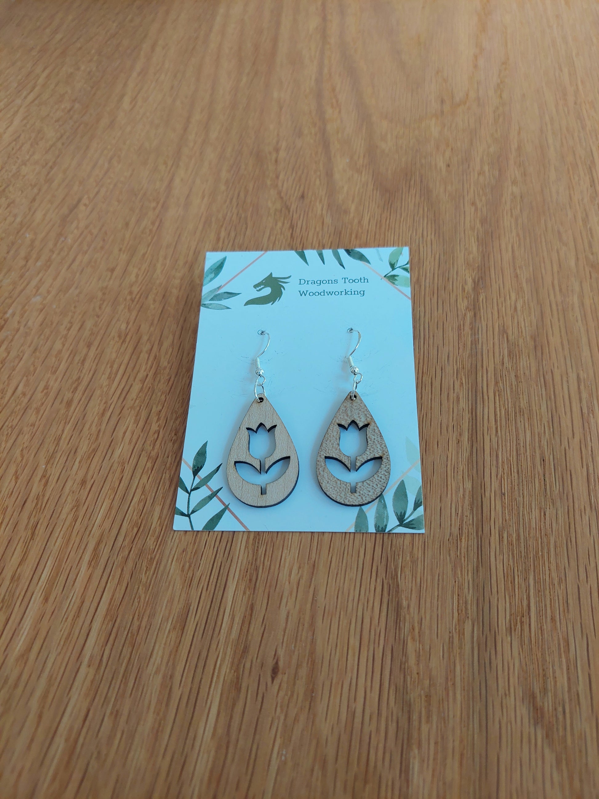 Bright blonde natural maple wood tulip dangle earrings featuring an elegant laser-cut floral silhouette design.